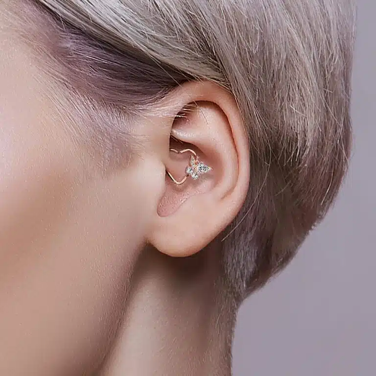 Daith-smycke i hjärtform med kristaller i ett öra