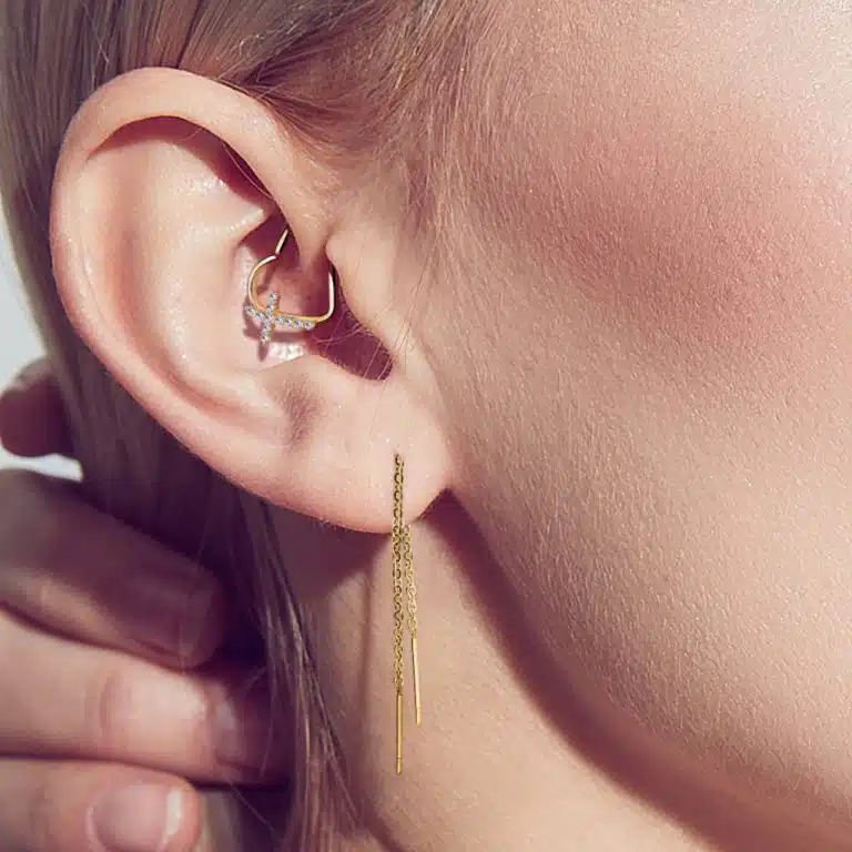 Daith-ring med hängande kedjor i ett öra